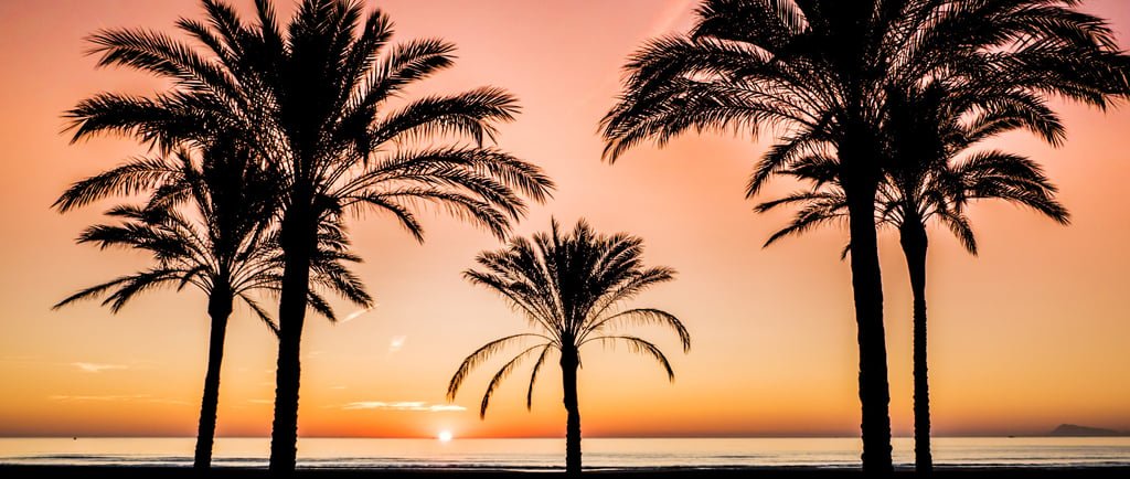 Imagen de un atardecer en la playa de Cullera con el sol bajando en el horizonte